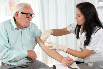 nurse with syringe is taking blood for test